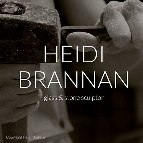 Close up of hands holding a large stone hammer getting ready to chisel stone.