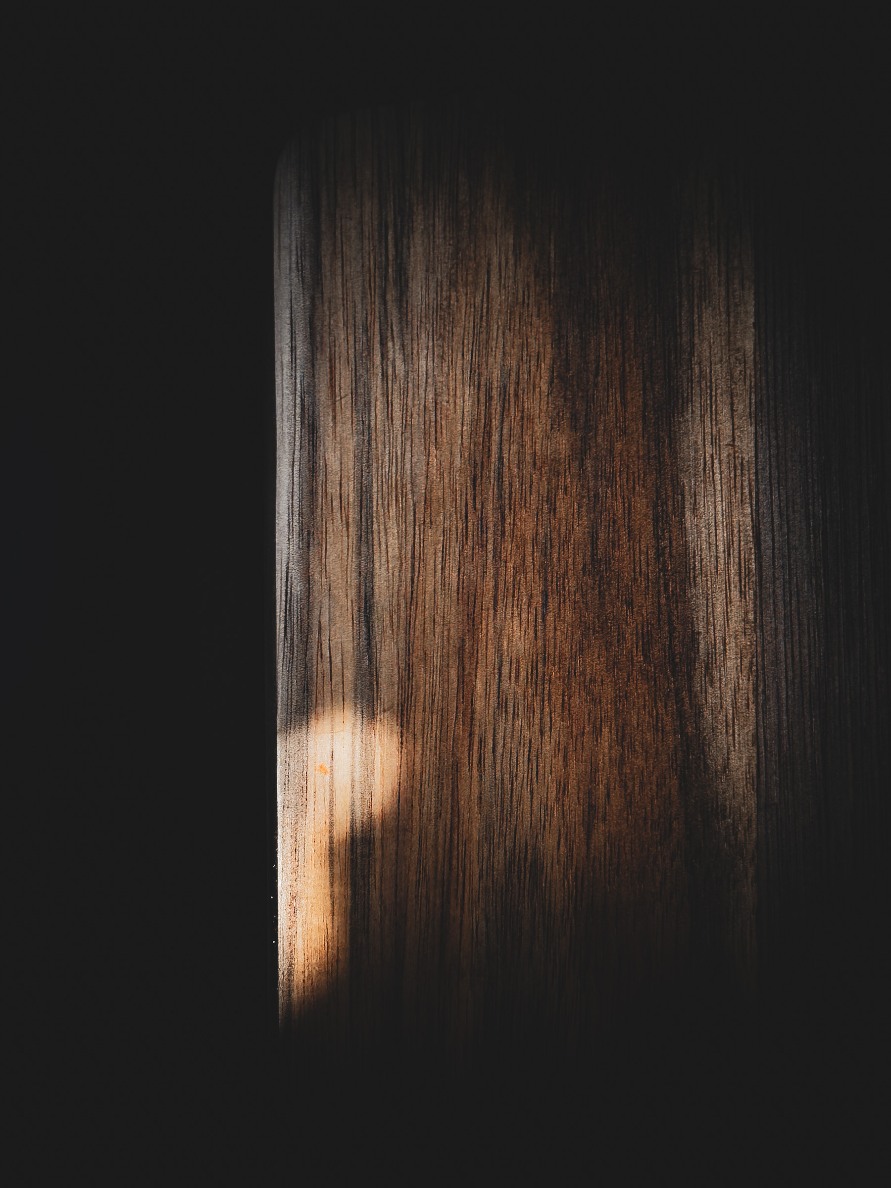Close-up of a walnut in warm light and shadow with a softly blurred basket in the background.